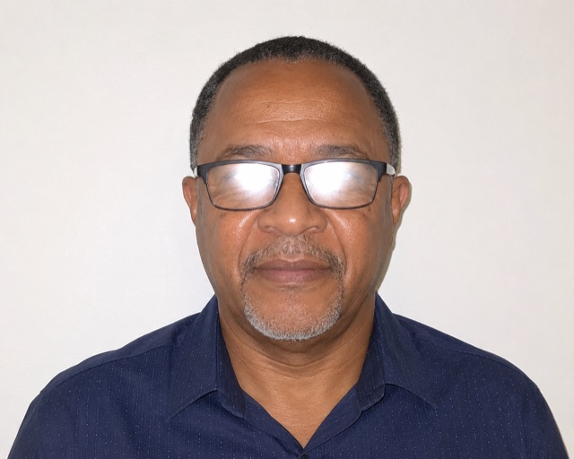 A portrait where camera flash has reflected off both spectacle lenses